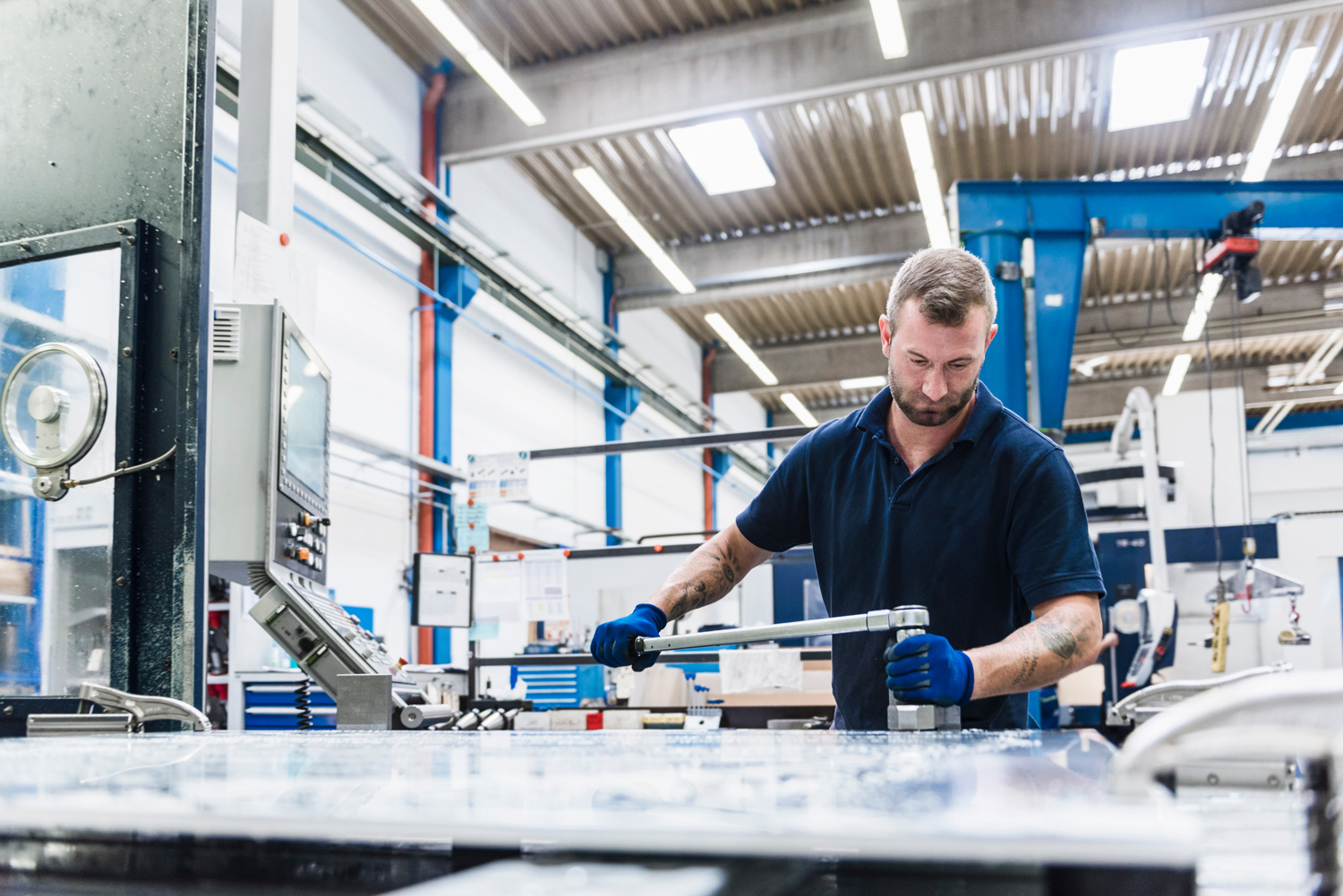 Produktionsmitarbeiter mit Drehmomentschlüssel am Arbeitstisch